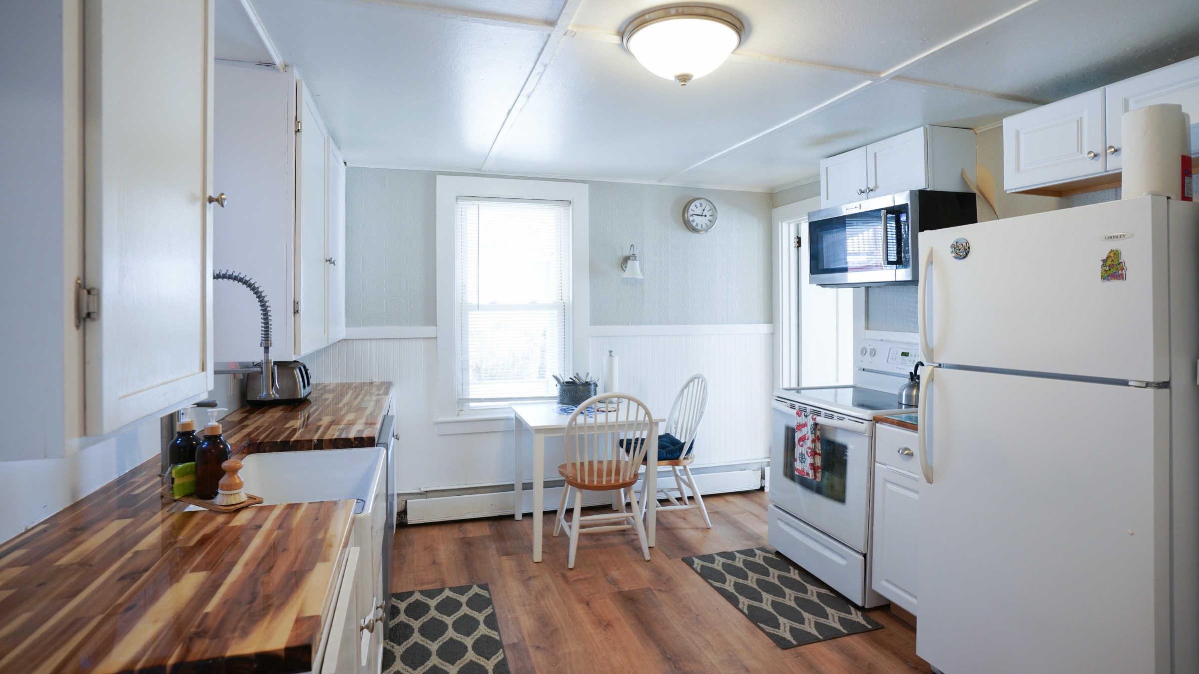 a kitchen with a stove refrigerator and table in a room