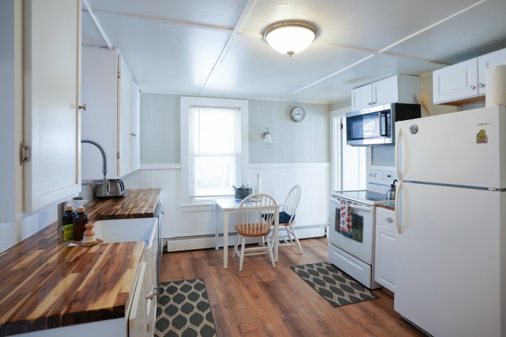 a kitchen with a stove refrigerator and table in a room