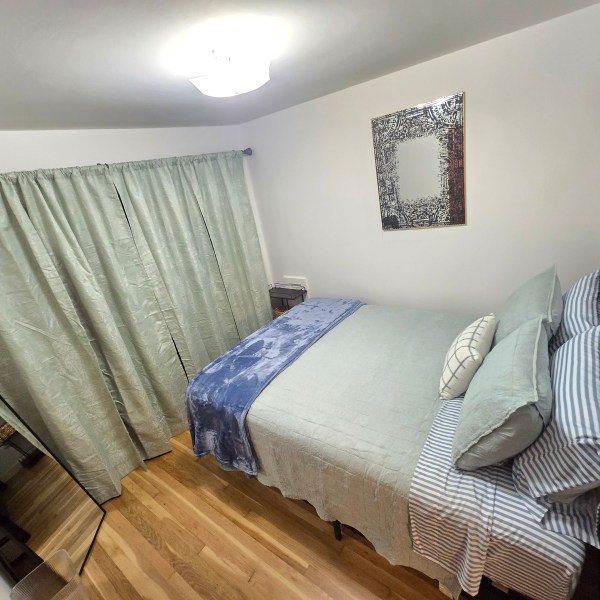 a bedroom with a bed and a chair in a room