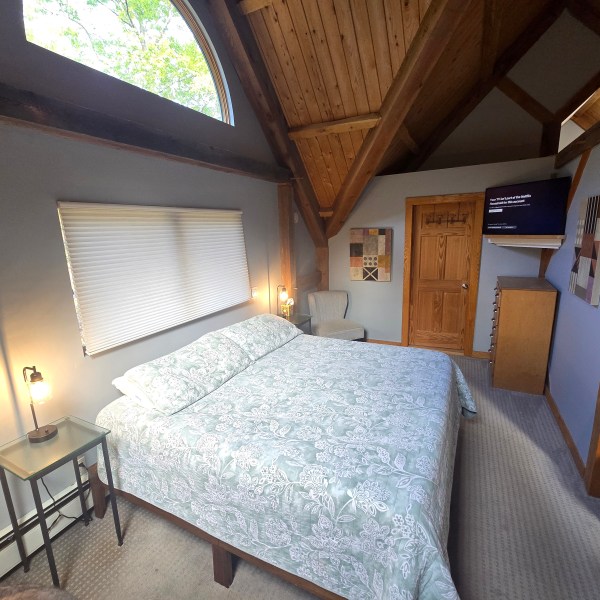 a bedroom with a bed and a chair in a room