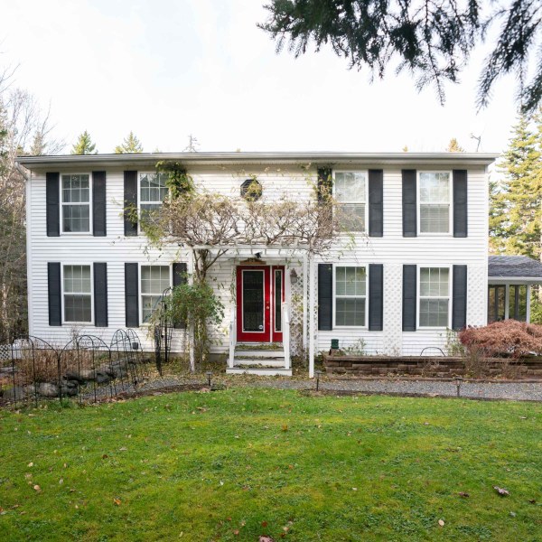 a large brick building with grass in front of a house